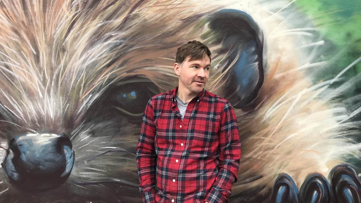 Allan Frater in front of a hedgehog mural